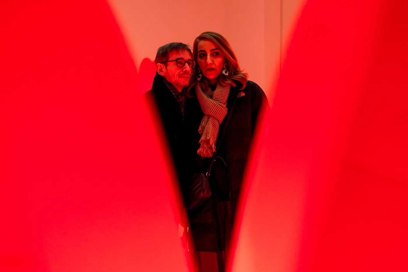 Two visitors immersed in the red glow between the petals