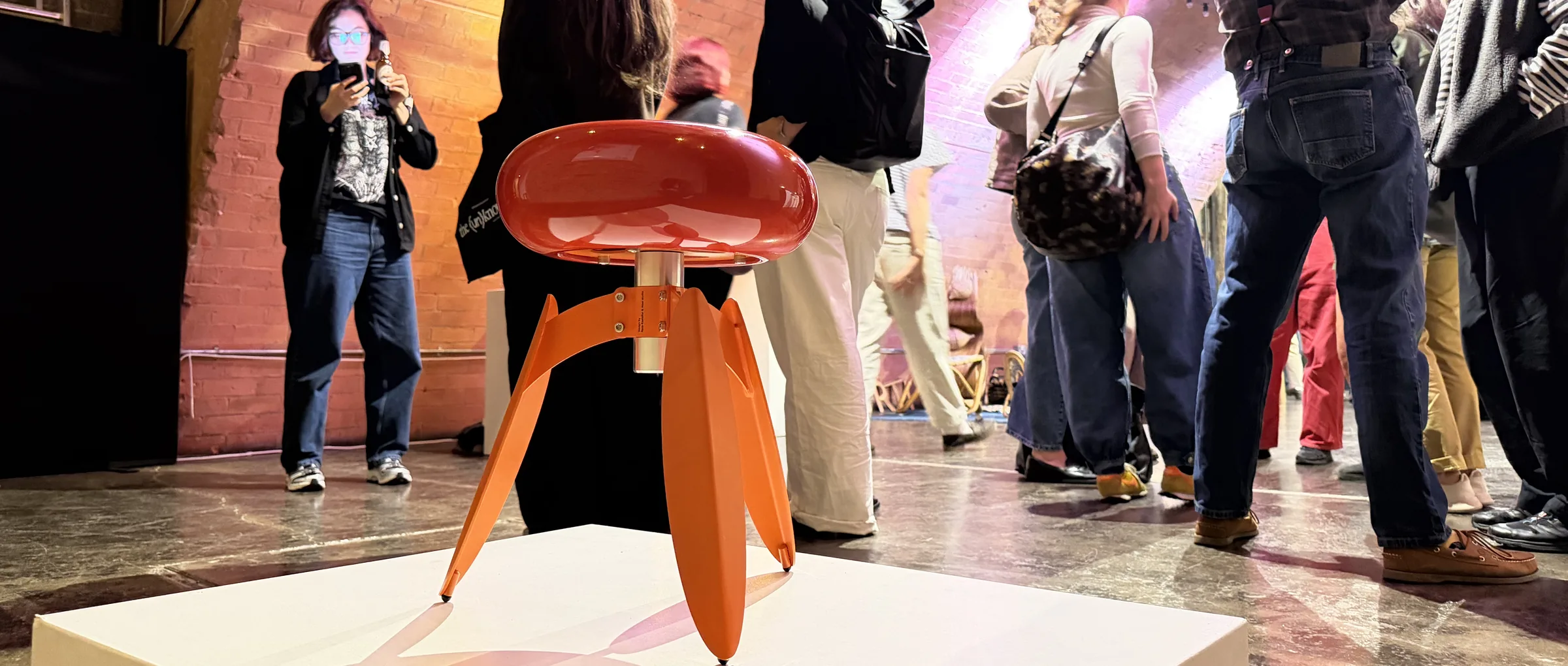 DOT Nut on a white plinth under the brick arches of Kachette, visitors gathered behind