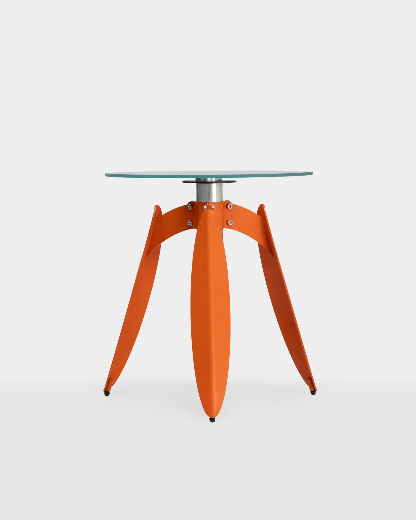 Dot table — a round glass top on rust-orange leaf-bent legs