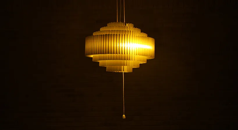 The stepped Keker pendant glowing warm in a darkened room