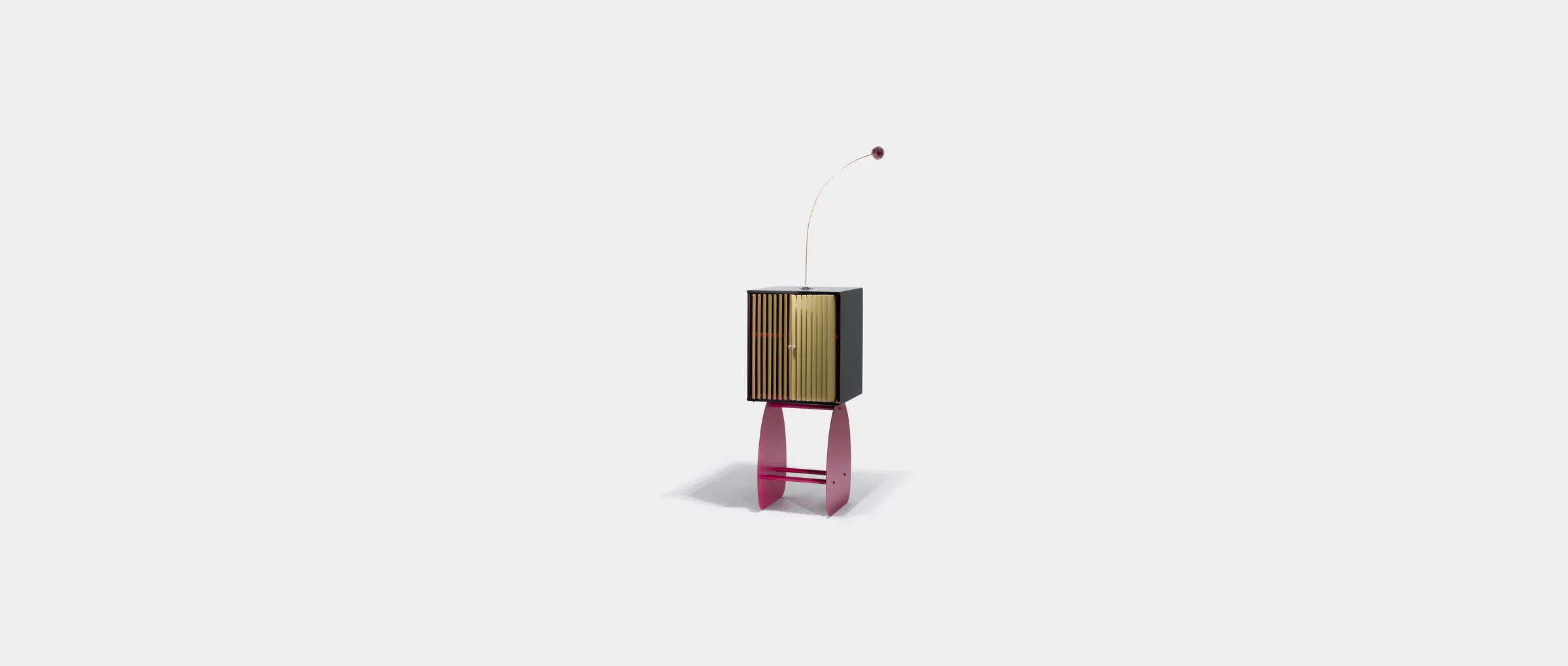 The Secret Cabinet in full — golden slats on curved pink legs, antenna on top