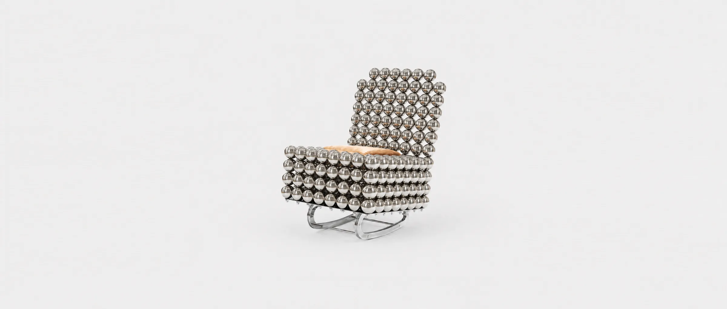 The Wishes lounge chair — chrome spheres cradling a fur cushion, on soft grey